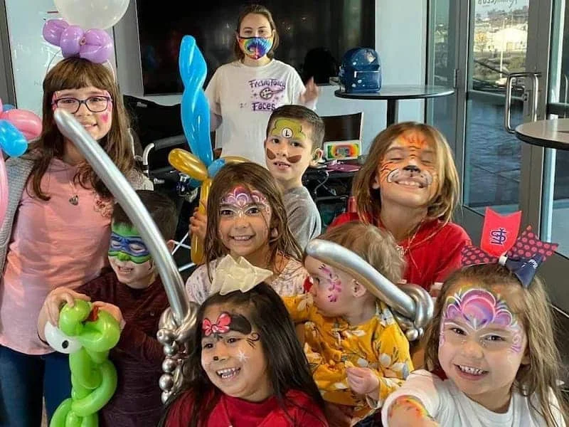 Kids with face paint and balloon animals
